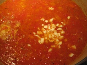adding garlic to the tomato soup