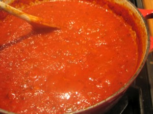 pasta sauce in pot being stirred on stovetop