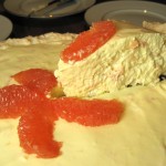 Cutting a piece of grapefruit pie with coconut meringue crust