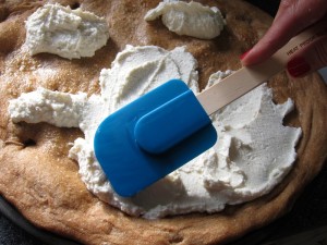 Spreading Ricotta cheese onto the pizza crust