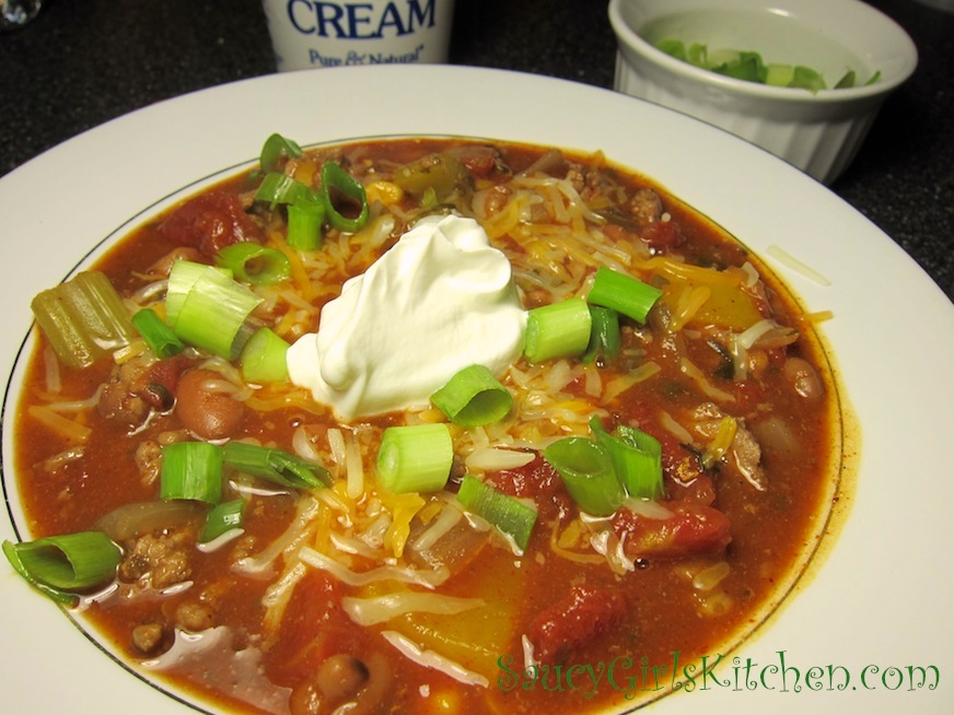 Homemade Chili topped with Cheese, Scallions and Sour Cream