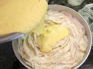 Pouring the mango mustard custard over the phyllo